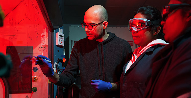 Three people working in a lab environment.