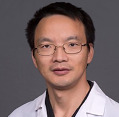 Portrait of Weidong Xiao smiling at the camera.